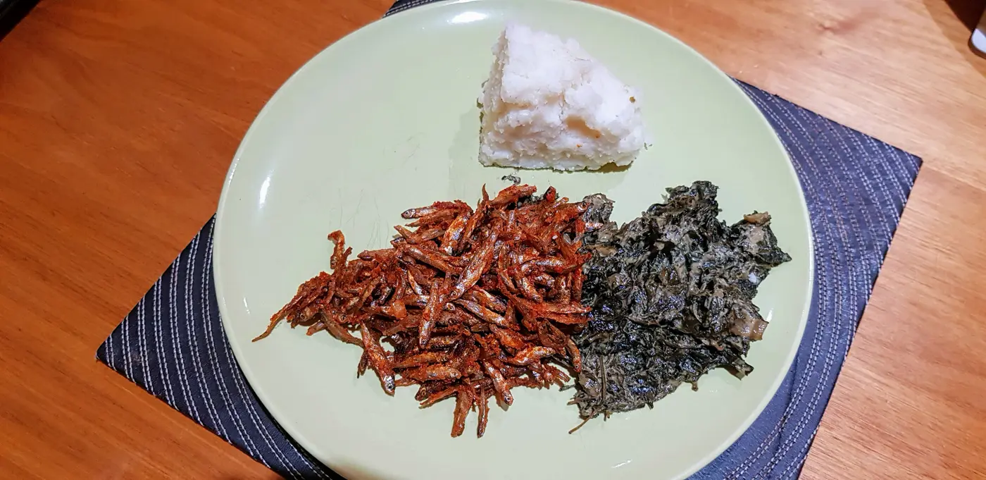 Traditional Kenyan meal featuring omena (silver cyprinid) served with vegetables and ugali